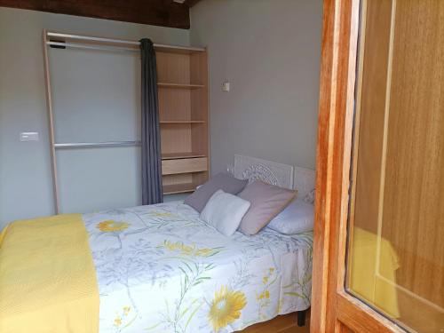 a small bedroom with a bed with flowers on it at Bico de Pedra in Santiago de Compostela