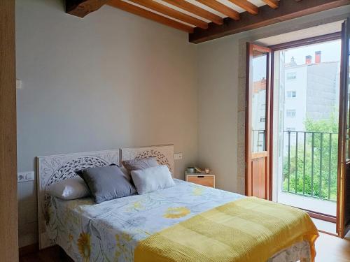 a bedroom with a bed and a large window at Bico de Pedra in Santiago de Compostela