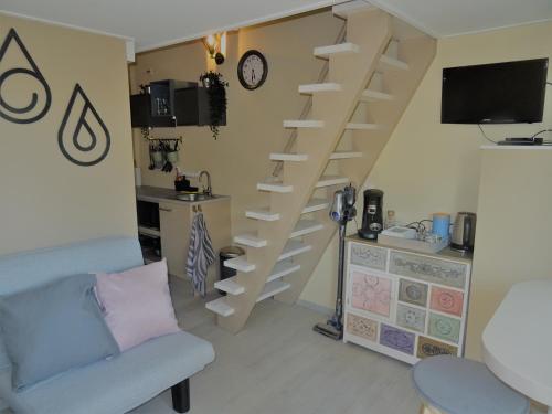 een woonkamer met een trap met een bank en een tafel bij B&B Het Onderduukertje in Wemeldinge