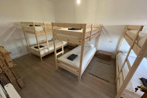 a room with three bunk beds in a room at Grip Surf Beach House Corrubedo in Corrubedo