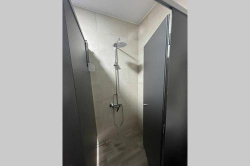 La salle de bains est pourvue d'une douche avec une porte en verre. dans l'établissement Grip Surf Beach House Corrubedo, à Corrubedo