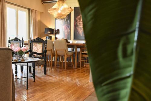 a living room with a dining room table and chairs at Pepromeno LUXURY APARTMENT IN THE CITY CENTER in Kalamata
