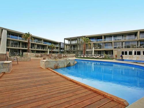 a swimming pool in front of a large building at Resort Hotel Room 107 in Torquay