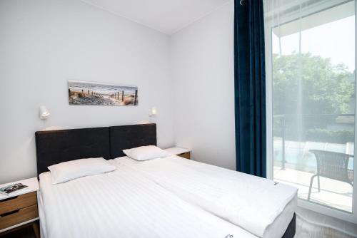 1 dormitorio con cama grande y ventana grande en Porto Bello en Jastrzębia Góra