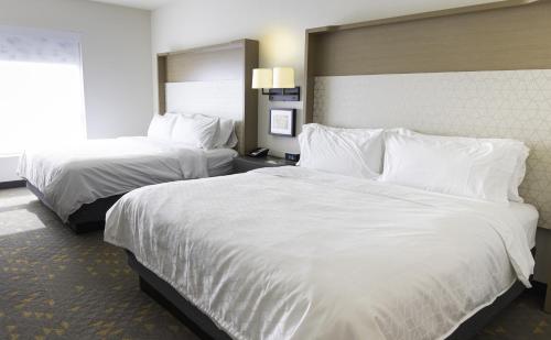 a hotel room with two beds with white sheets at Holiday Inn Glendale - Stadium & Ent Dist by IHG in Glendale