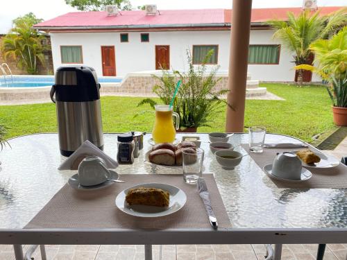 een tafel met borden eten en een drankje erop bij KILLA Casa Hospedaje in Iquitos
