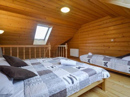 シュツァブニツァにあるDom Madeyskiの木造キャビン内のベッドルーム1室(ベッド2台付)