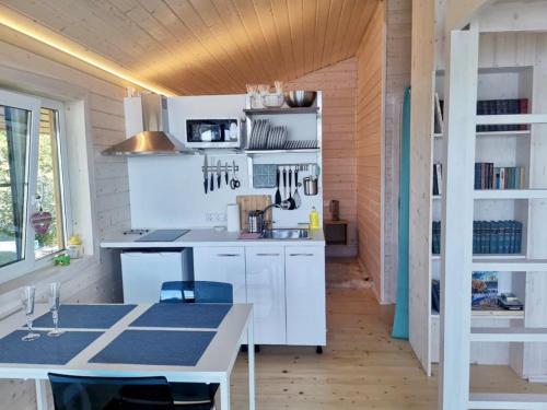 a kitchen with white cabinets and a table at Zaykina Dacha in Konchezero