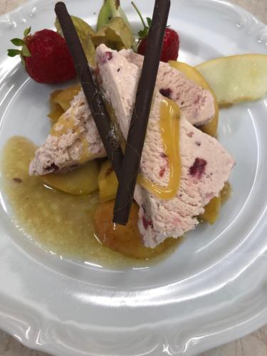 a white plate with a piece of cake and fruit at Staby Gårdshotell in Högsby
