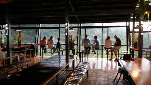 a group of people walking around a room with windows at Celeste Mountain Lodge in Bijagua