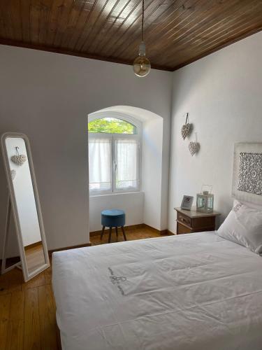 a bedroom with a white bed and a window at Casa do Arco in Abiul