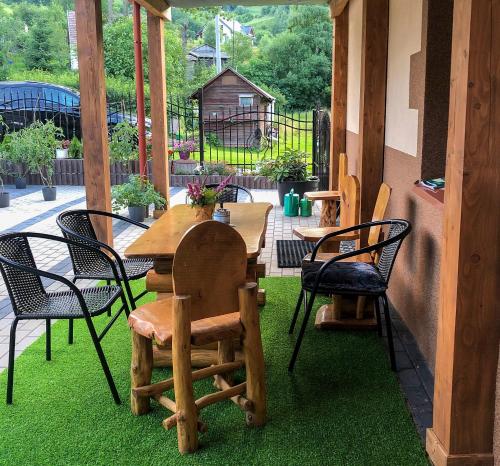 a patio with a wooden table and chairs on grass at Apartament u Bronka in Duszniki Zdrój