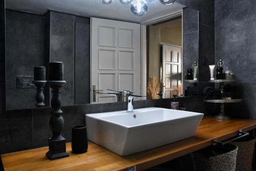 a bathroom with a white sink and a mirror at Pepromeno LUXURY APARTMENT IN THE CITY CENTER in Kalamata