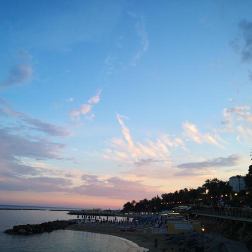 a group of people standing on a beach near the water at Sanremo Class New in Sanremo