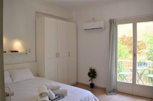 - une chambre blanche avec un lit et une fenêtre dans l'établissement The Heart Of Athens - Perfect Retreat For 2 Guests, à Athènes