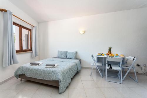 1 dormitorio con cama, mesa y escritorio en VILAMOURA MARINA C.A. APARTMENTS, en Vilamoura