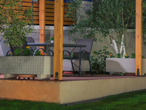 a table and chairs on a patio with plants at Spitakia-Cozy & Comfy Apartments 10minutes from the airport in Artemida