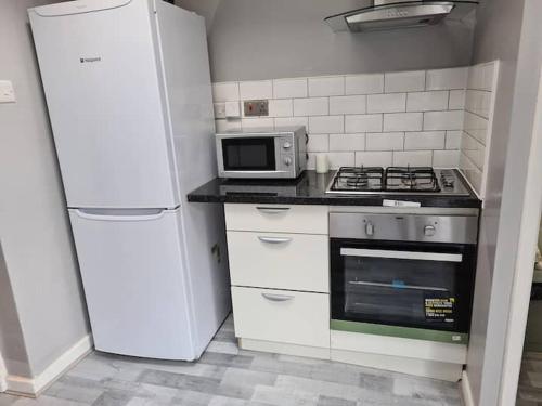 a kitchen with a refrigerator and a stove and a microwave at Next to Liverpool Stadium in Liverpool