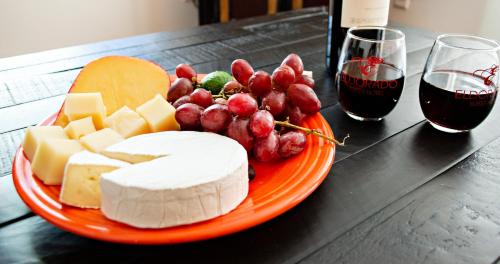 a plate of cheese and grapes and a glass of wine at Eldorado Suites Hotel in Bisbee