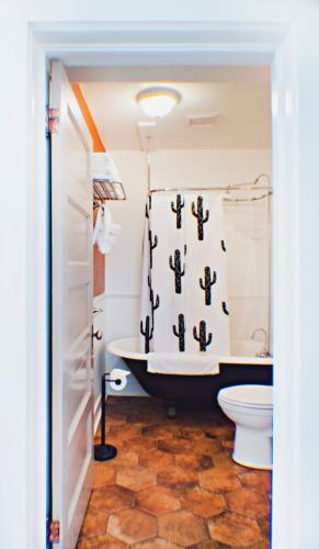 a bathroom with a tub and a shower curtain at Eldorado Suites Hotel in Bisbee