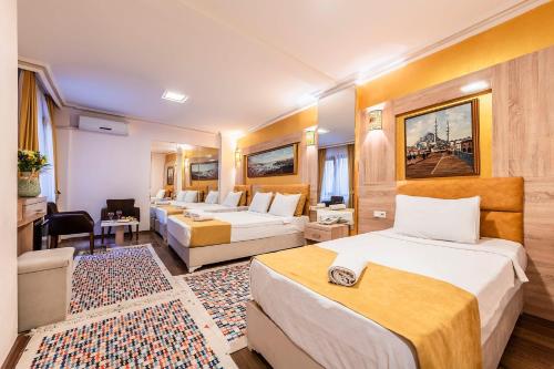 a hotel room with two beds and a living room at Kadirga Antik Hotel - Sultanahmet in Istanbul
