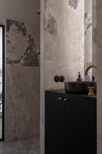 ein Badezimmer mit Waschbecken und Dusche in der Unterkunft Bōheme House in Kaunas