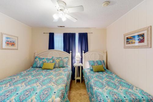 a bedroom with two beds and a ceiling fan at Sand Quarters in Edisto Beach