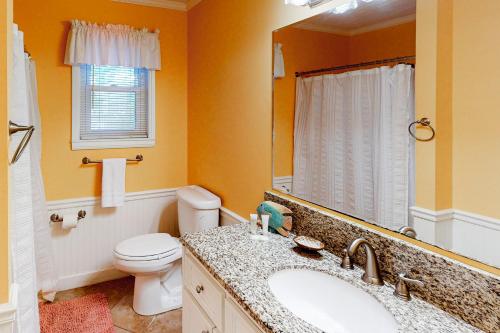 a bathroom with a sink and a toilet and a mirror at Sand Quarters in Edisto Beach