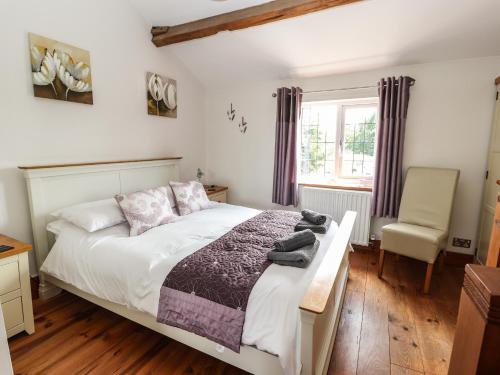 a bedroom with a bed and a chair at Mill Lane Cottage in Chester