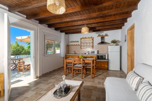 a living room with a table and a kitchen at Casa al mare in Archangelos