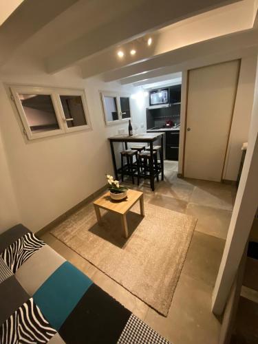 a small living room with a table and a kitchen at studio au calme pres des plages in Six-Fours-les-Plages