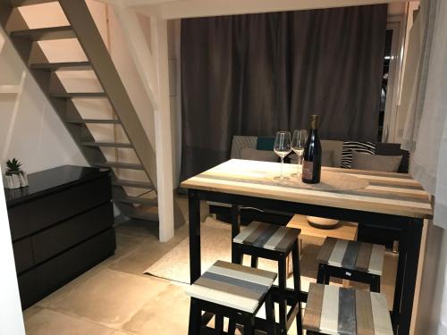 a dining room table with wine glasses and a staircase at studio au calme pres des plages in Six-Fours-les-Plages