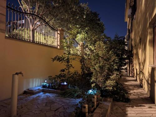 un callejón con una valla y algunos árboles y luces en Eros Rooms en Split