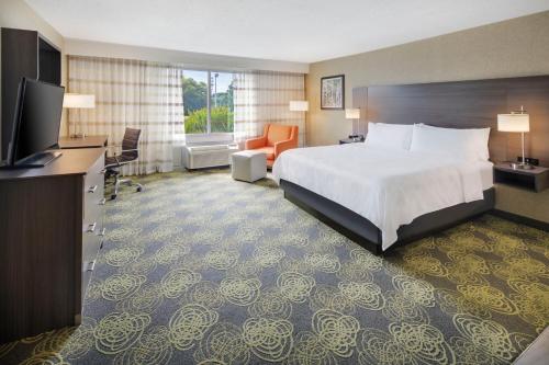 a hotel room with a bed and a flat screen tv at Holiday Inn University Area Charlottesville by IHG in Charlottesville