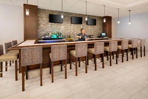 a bar in a hotel room with a woman standing at a counter at Holiday Inn University Area Charlottesville by IHG in Charlottesville