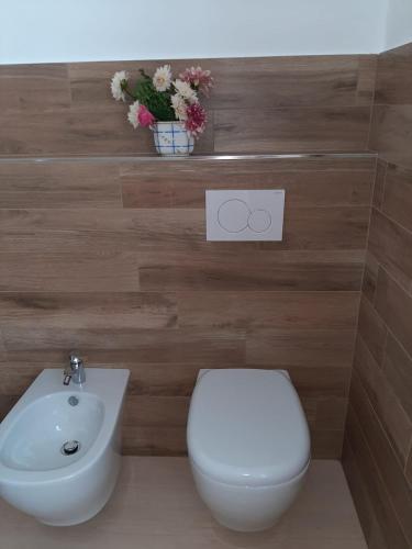 a bathroom with a white toilet and a sink at B&B Casa Lilla in Verzuolo