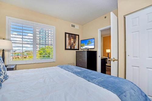 a bedroom with a bed and a television and a window at Near Disney - 1 Bed King Suite - Pool and Hot Tub in Orlando