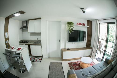 ein Wohnzimmer mit einem Sofa und einer Küche in der Unterkunft Apartamento Completo e moderno na Serra em Itaipava in Petrópolis