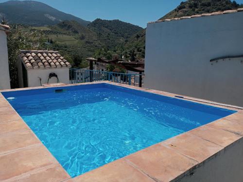 una piscina azul al lado de una casa en Casa Cueva “La Estrella”, en Granada