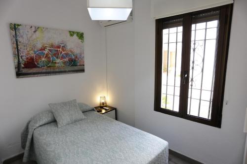 a bedroom with a bed and a window at Calle San Basilio - Patios. Aparcamiento gratis in Córdoba
