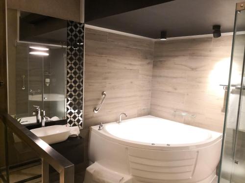 a bathroom with a large tub and a sink at Hotel Las Lomas in Lima