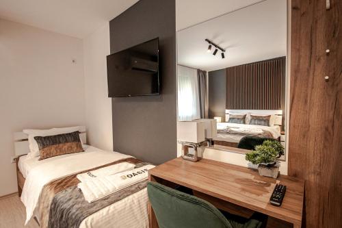 a bedroom with two beds and a desk and a mirror at OASIS Apartments in Gevgelija