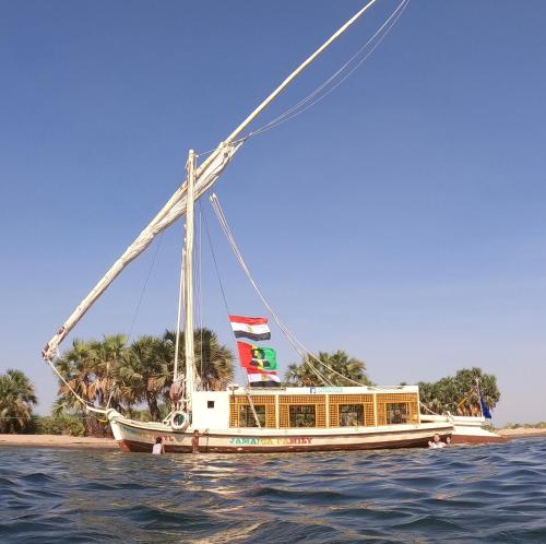 a boat in the water with people on it at JJ Jamaica Felucca in Aswan