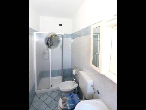 La salle de bains est pourvue d'une douche et de toilettes blanches. dans l'établissement Agriturismo Al Brich Quadriple room with breakfast, à Albaretto Della Torre 