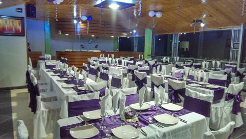 a large banquet hall with white tables and chairs at Refugio Turistico & Restaurante Dylam in Aquitania