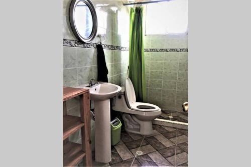 a bathroom with a toilet and a sink and a mirror at CASA VACACIONAL DE PLAYA in Nueva Gorgona