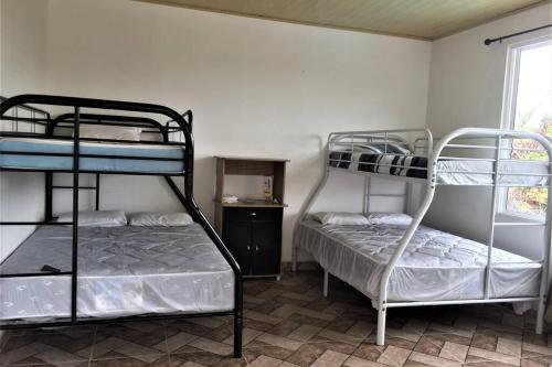 a room with two bunk beds and a window at CASA VACACIONAL DE PLAYA in Nueva Gorgona