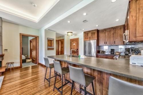 una cucina con armadi in legno e un bar con sgabelli di Luxury 2Br Residence Steps From Heavenly Village & Gondola Condo a South Lake Tahoe