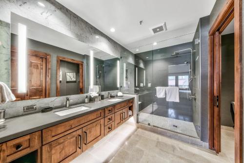 y baño con 2 lavabos y ducha. en Luxury 2Br Residence Steps From Heavenly Village & Gondola Condo en South Lake Tahoe