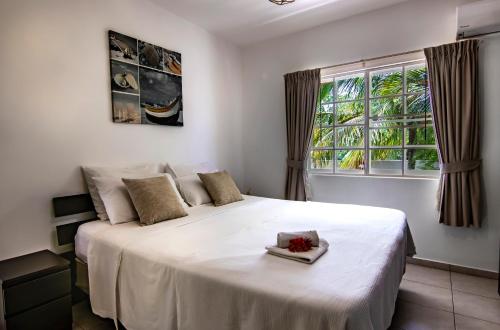 ein Schlafzimmer mit einem großen weißen Bett und einem Fenster in der Unterkunft Chico's Seru Hulanda Resort in Willemstad
